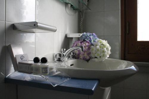 a bathroom sink with flowers on top of it at Hotel Costellazioni in Troina
