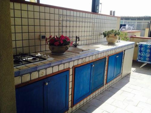a kitchen with blue cabinets and a sink and a stove at Casa Laura in San Vito lo Capo