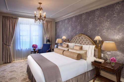 a bedroom with a large white bed and a chandelier at InterContinental New York Barclay Hotel by IHG in New York