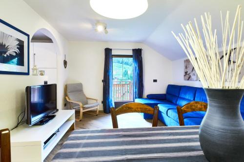 ein Wohnzimmer mit einer blauen Couch und einer Vase in der Unterkunft Apartment Katzenkopf in Leutasch