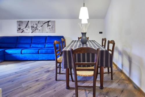 einen Esstisch mit Stühlen und eine blaue Couch in der Unterkunft Apartment Katzenkopf in Leutasch