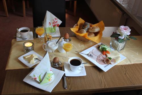 einen Tisch mit Teller mit Speisen und Tassen Kaffee in der Unterkunft Cafe Zur Talsperre in Chemnitz