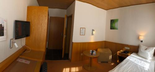 a hotel room with a bed and a television at Hotel Dorheimer Hof in Friedberg