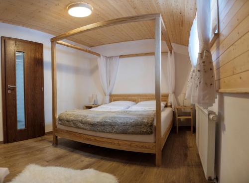 a bedroom with a canopy bed in a room at Chata Marguška - U Fera in Oščadnica