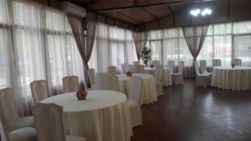una habitación llena de mesas y sillas con manteles blancos en Golubaya Volna, en Rostov-on-Don