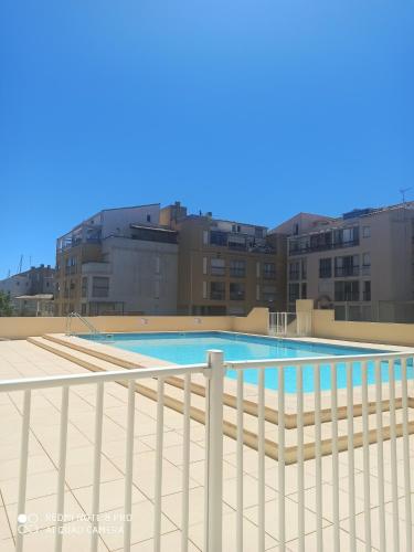une piscine sur le toit d'un immeuble dans l'établissement Résidence Orion position centrale piscine parking privé terrasse, au Cap d'Agde