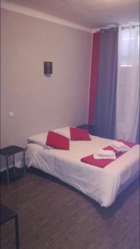 una habitación de hotel con una cama con almohadas rojas. en Le toro bleu, en Montier-en-Der