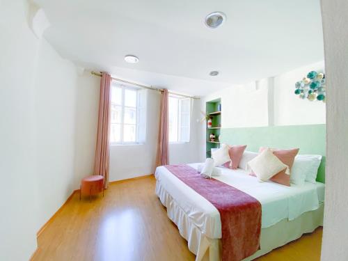 a bedroom with a bed with white sheets and pillows at OROROSA Lucca City Center Apartment in Lucca
