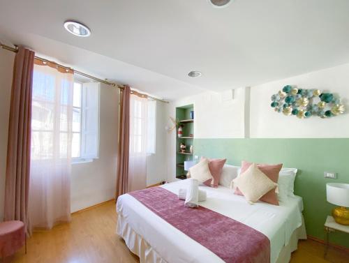 a bedroom with a large white bed in a room at OROROSA Lucca City Center Apartment in Lucca