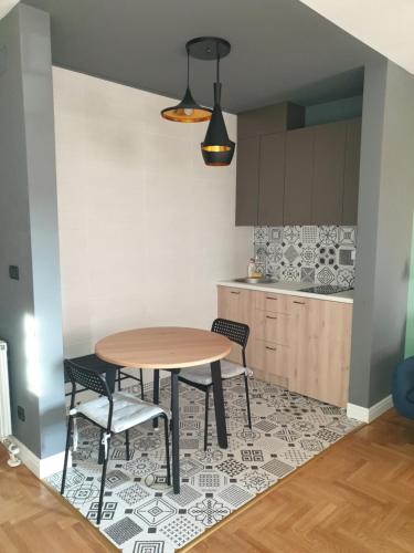 a kitchen with a table and chairs on a rug at TiTo in Belgrade