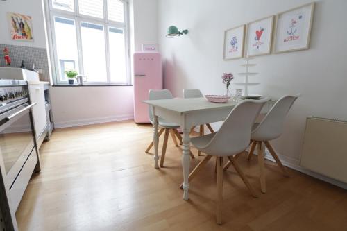 a kitchen with a table and chairs and a pink refrigerator at Kleine 25 in Solingen