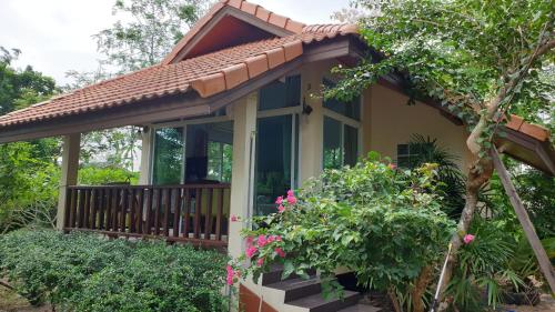 a small house with a porch and flowers at Wandee Resort Bankrut in Ban Krut