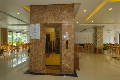a lobby with a gold door and tables and chairs at Anise hotel in Phu Quoc