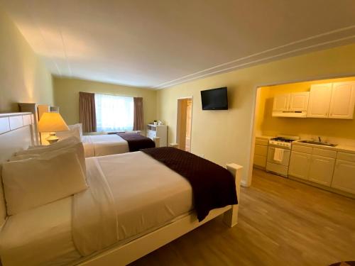 a hotel room with two beds and a kitchen at Hollywood Celebrity Hotel in Los Angeles