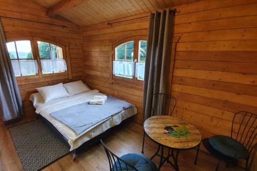 1 dormitorio con 1 cama, mesa y sillas en Domek na Winnicy, en Dąbrówka Szczepanowska