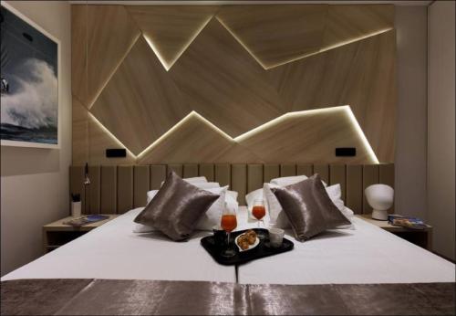 a bed with a tray of food and two glasses at Sailor Boutique Rooms in Split