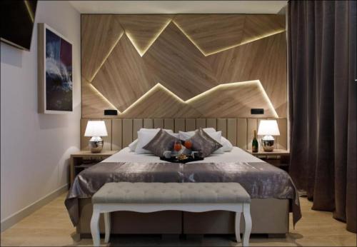 a bedroom with a large bed with a wooden headboard at Sailor Boutique Rooms in Split