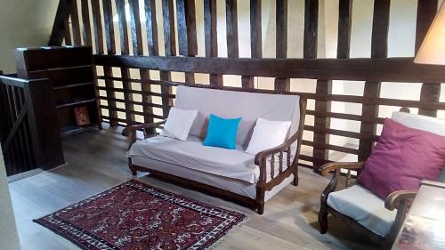- une chaise avec deux oreillers bleus dans la chambre dans l'établissement Domaine de Gentilly, à Saint-Maurice-les-Chérencey