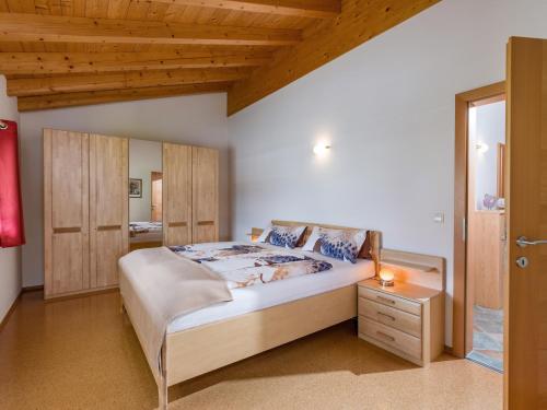 a bedroom with a large bed and a wooden ceiling at Ferienwohnung Eisenmann in Bad Häring