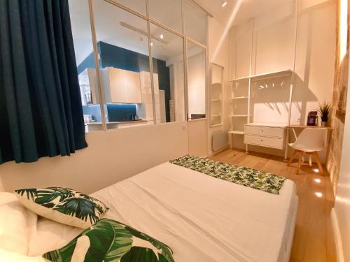 une petite pièce avec un lit et une fenêtre dans l'établissement Perle Bleue - Charme & Sérénité Hyper-Centre, à Montpellier