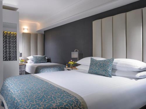 a hotel room with two beds with blue and white pillows at Asgard Apartments in Westport