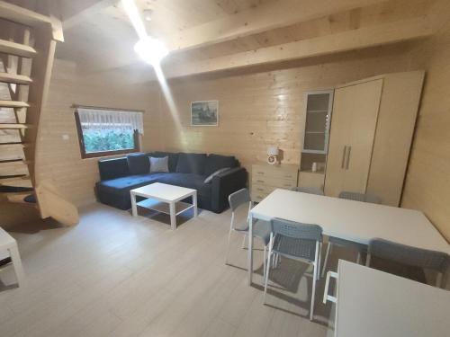 a living room with a blue couch and a table at Agroturystyka i Domki Zacisze in Jarosławiec