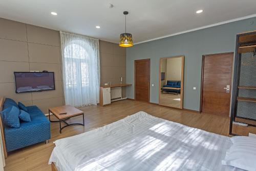 a large bedroom with a bed and a blue couch at Koisha in Bishkek