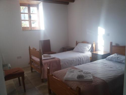 ein kleines Schlafzimmer mit 2 Betten und einem Fenster in der Unterkunft Georgia's House in Paphos City