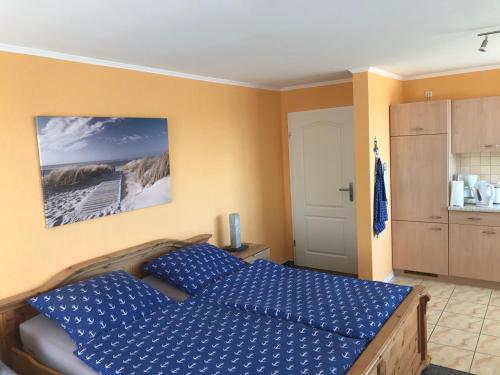 a bedroom with a blue bed and a kitchen at Residenz am Peeneplatz in Peenemünde