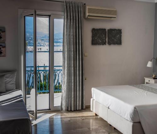 a bedroom with a bed and a balcony at Drossinos Studios in Poros