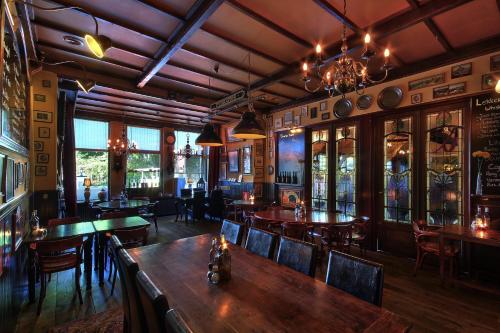 a bar with wooden tables and chairs in a restaurant at Hotel Eethuys de Wormshoef in Lunteren