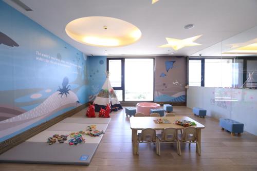 Habitación infantil con cama, mesa y sillas en Lakeshore Hotel Hualien en Hualien