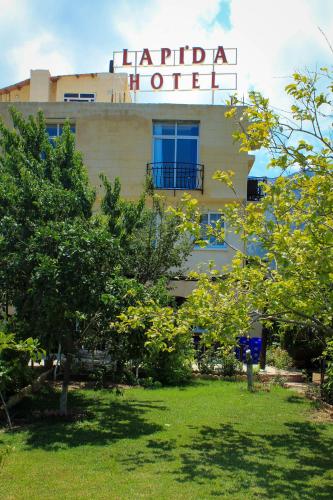 a hotel with a sign on top of a building at Lapida Garden in Kérynia