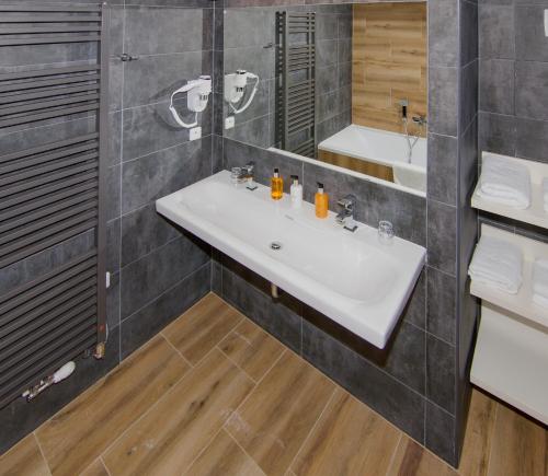 a bathroom with a white sink and a mirror at Hotel Srní a Depandance in Srní
