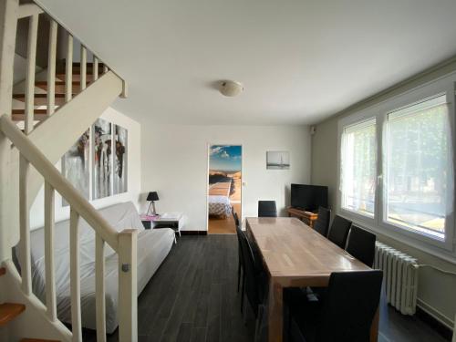 uma sala de estar com uma escada e uma mesa em CENTRE CHATELAILLON GRAND T3** AVEC COUR 100m PLAGE em Châtelaillon-Plage