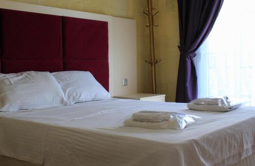 a bed with two towels sitting on top of it at Lapida Garden in Kérynia
