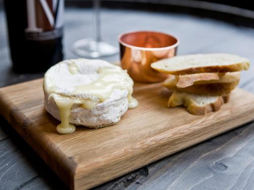 a wooden cutting board with a sandwich and a drink at Montcalm Brewery Townhouse in London