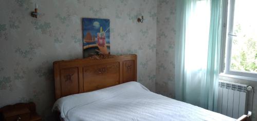 ein Schlafzimmer mit einem Bett, einer Kommode und einem Fenster in der Unterkunft chambre d'hôte in Campagne