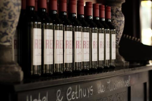 a bunch of wine bottles sitting on a shelf at Hotel Eethuys de Wormshoef in Lunteren