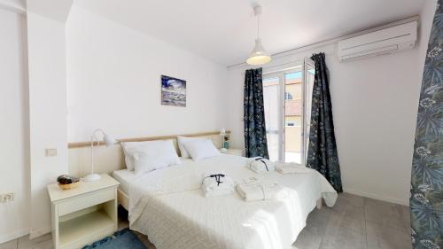 um quarto branco com 2 camas e uma janela em STELLA deluxe SUPERIOR 5 star apartment, your piece of heaven by the sea & park, with sea view em Novigrad Istria