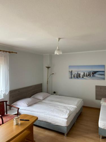 1 dormitorio con cama blanca y mesa en POD BOROWIKIEM, en Grzybowo