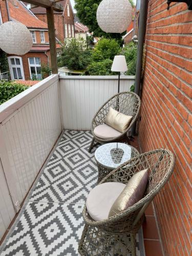 d'une terrasse avec 2 chaises et une table sur un balcon. dans l'établissement Ferienwohnung Altstadt Perle_ 15164, à Leer