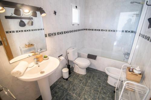 een badkamer met een wastafel, een toilet en een bad bij Tranquilo, luminoso y en el centro de la ciudad in Valencia