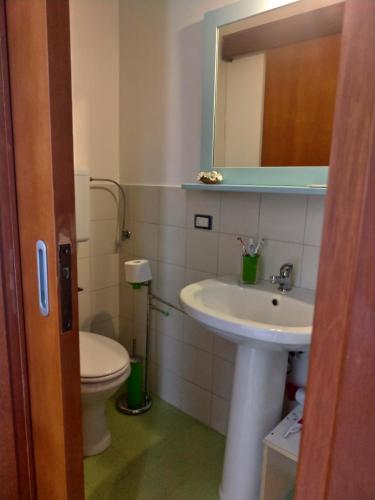 a bathroom with a sink and a toilet and a mirror at B&B Barone in Castro di Lecce