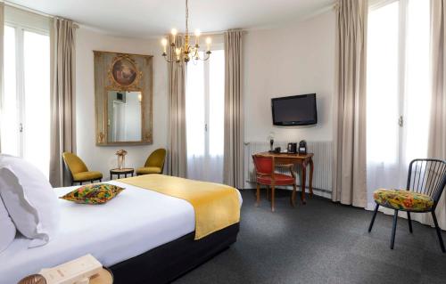 a hotel room with a bed and a table and chairs at Hotel Saint Regis in Chalon-sur-Saône