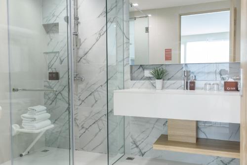 un baño con lavabo y ducha en Alix Bangkok Hotel, en Bangkok