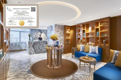 a living room with a blue couch and a table at Amari Johor Bahru in Johor Bahru