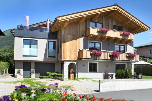 a house with a balcony with flowers on it at Annika Appartements in Zell am See