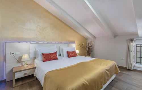 a bedroom with a large white bed with red pillows at Boutique Hotel Melissa in Poreč