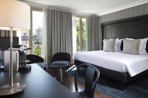een hotelkamer met een bed en een tafel en stoelen bij Hôtel Elysées Régencia in Parijs